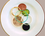 Kirsten Kötter: Konstruktives Kochen, Komposition nach Rodtschenko, 2009, Zwiebelringe mit Paprika gedünstet, gefärbt, Pumpernickel (rund, mit Senf), Salami, Schinkenwurst (rund)